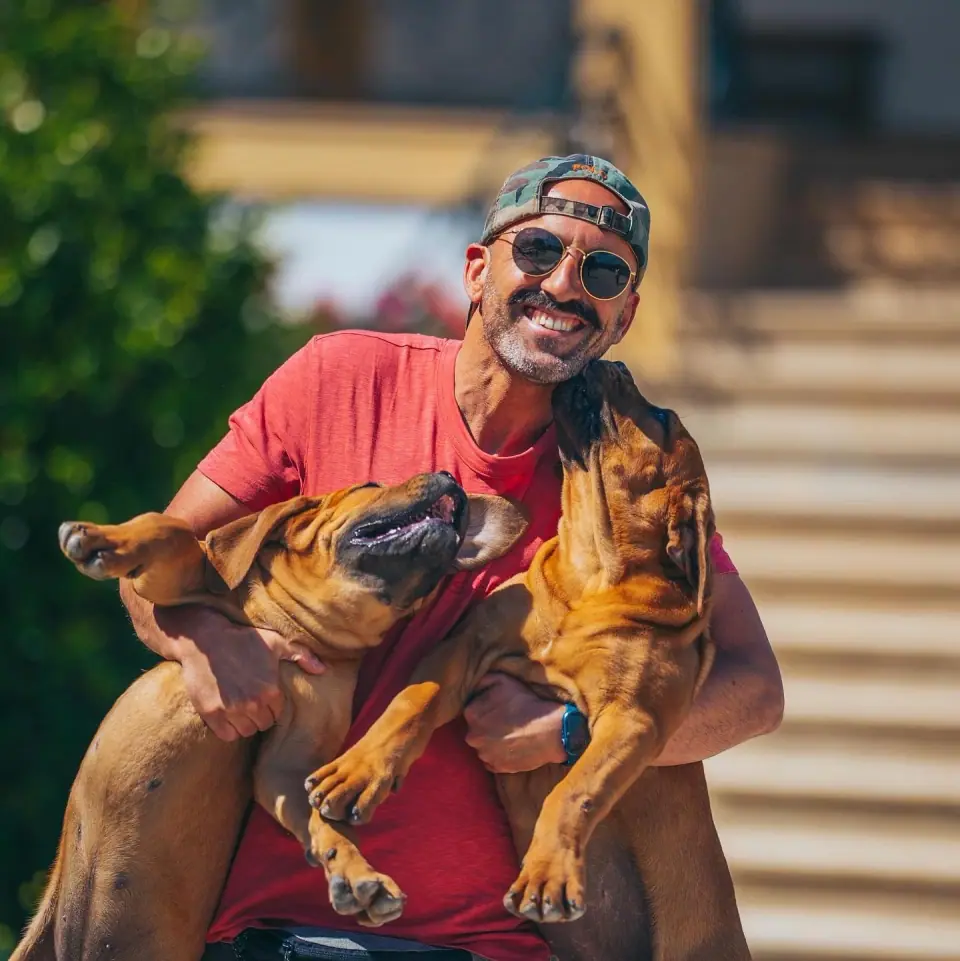 Rui Navarro holding two young Boerboels outdoors